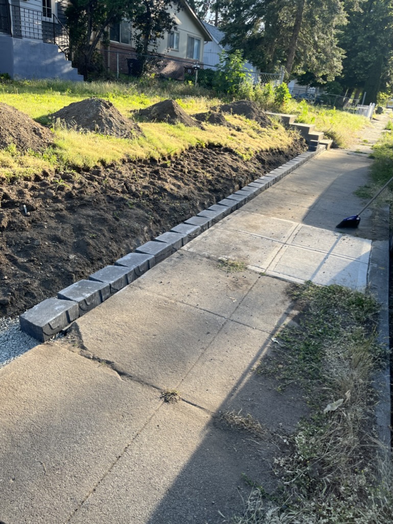 First layer of bricks along a ditch to create a retaining wall.